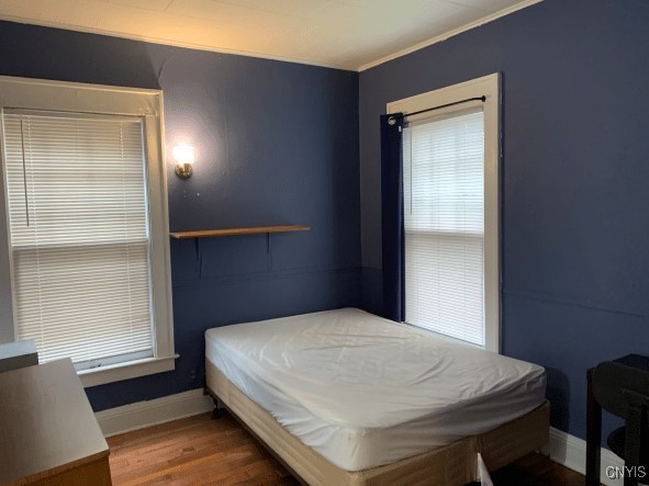 bedroom with baseboards and wood finished floors