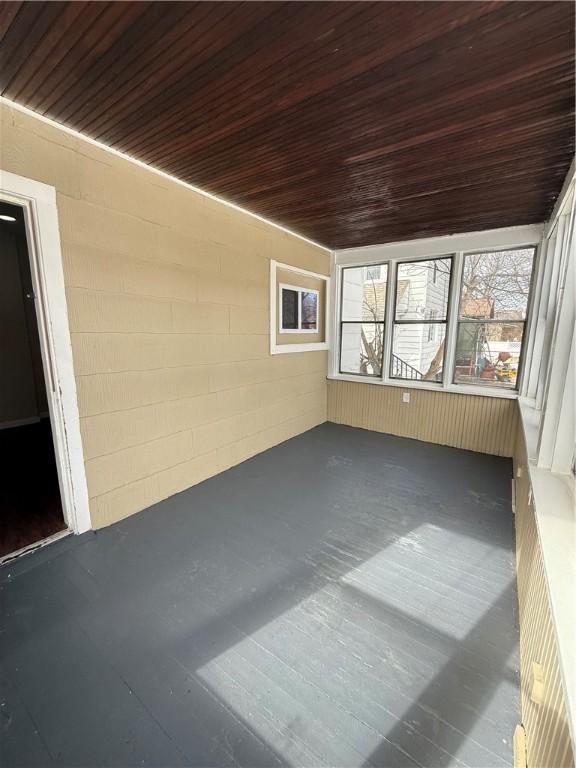 unfurnished sunroom featuring wood ceiling