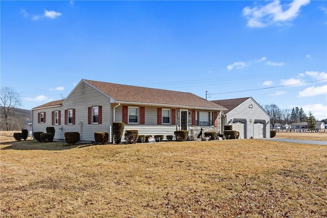 single story home with a detached garage and a front lawn