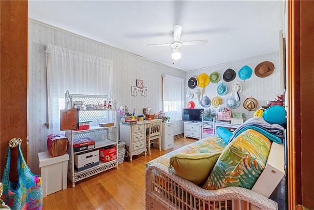 bedroom featuring ceiling fan, wood finished floors, and wallpapered walls