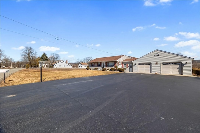 ranch-style house featuring aphalt driveway and a garage