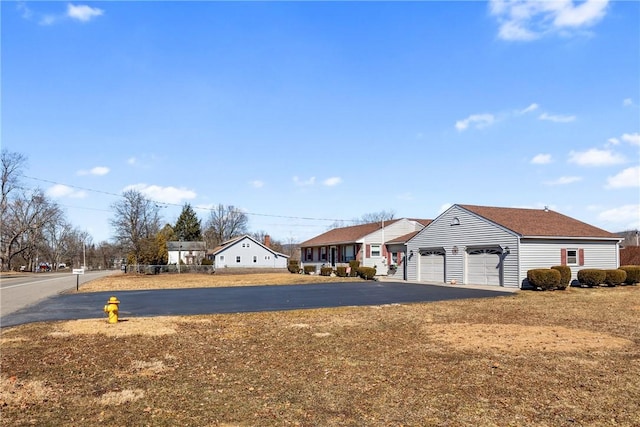 view of front of house with a residential view, a garage, and driveway