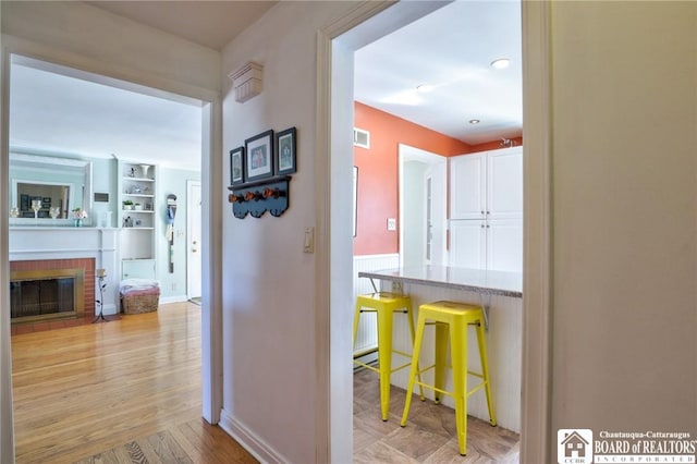 hallway featuring light wood finished floors and visible vents