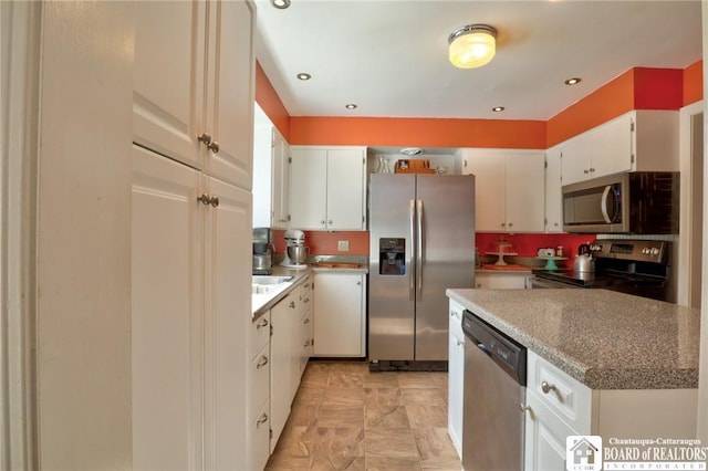 kitchen with white cabinetry, recessed lighting, a sink, and stainless steel appliances