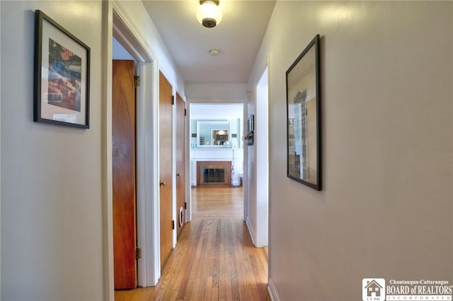 hallway featuring baseboards and light wood-style flooring