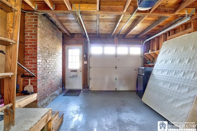 garage featuring a garage door opener and freestanding refrigerator