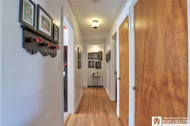 hallway with light wood-style flooring and baseboards