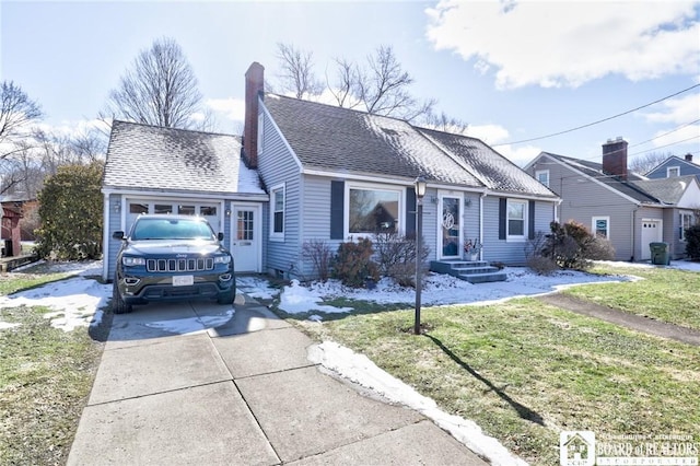 view of front of home with driveway, roof with shingles, a front yard, a garage, and a chimney