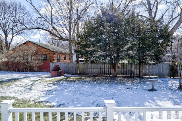 snowy yard featuring fence