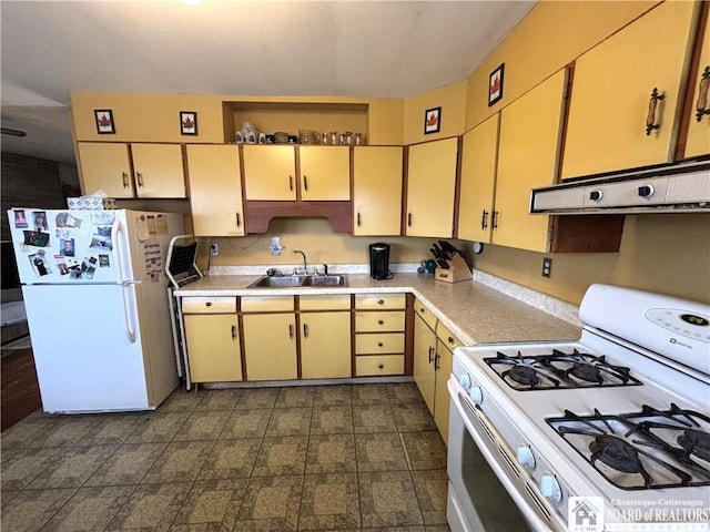 kitchen featuring under cabinet range hood, white appliances, light countertops, and a sink