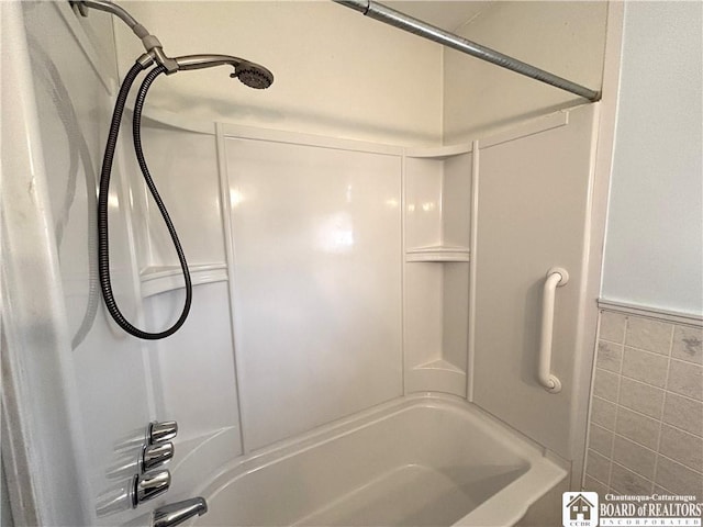 bathroom with tile walls and washtub / shower combination