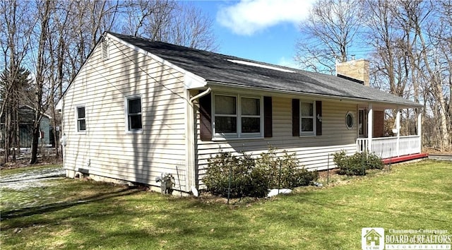 view of side of property featuring a lawn and a chimney