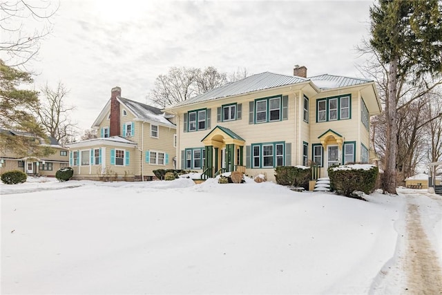 view of front of home with a chimney and metal roof