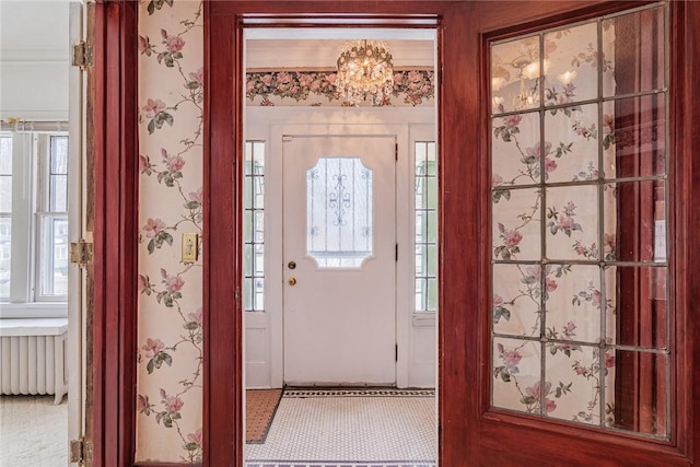 foyer entrance with wallpapered walls, radiator heating unit, and a wealth of natural light