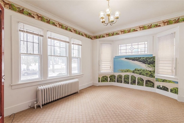 empty room with a chandelier, baseboards, ornamental molding, and radiator heating unit