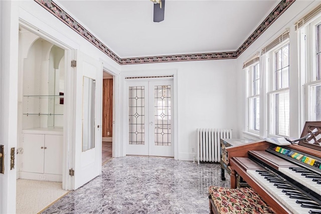 interior space with french doors, radiator heating unit, and ornamental molding