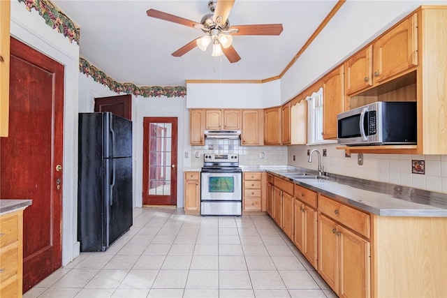 kitchen with light tile patterned floors, a sink, under cabinet range hood, appliances with stainless steel finishes, and tasteful backsplash