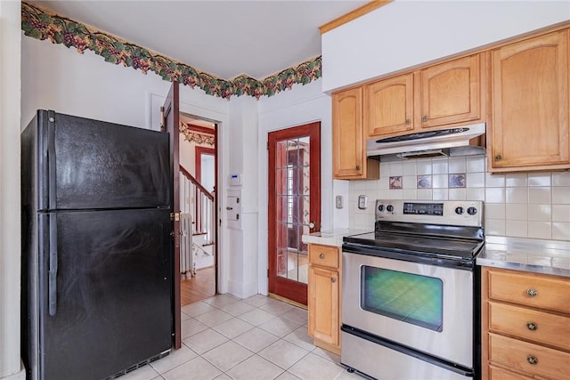 kitchen with decorative backsplash, under cabinet range hood, freestanding refrigerator, and stainless steel range with electric cooktop