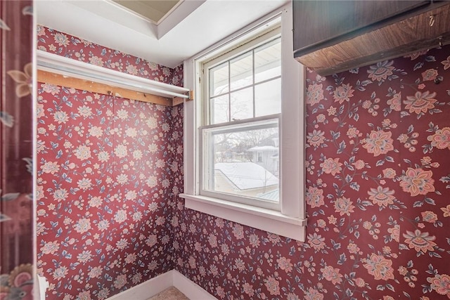 bathroom with wallpapered walls and baseboards