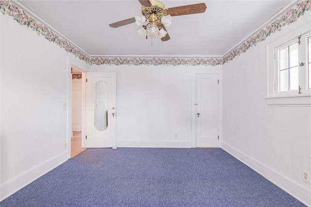 empty room with crown molding, baseboards, and carpet floors