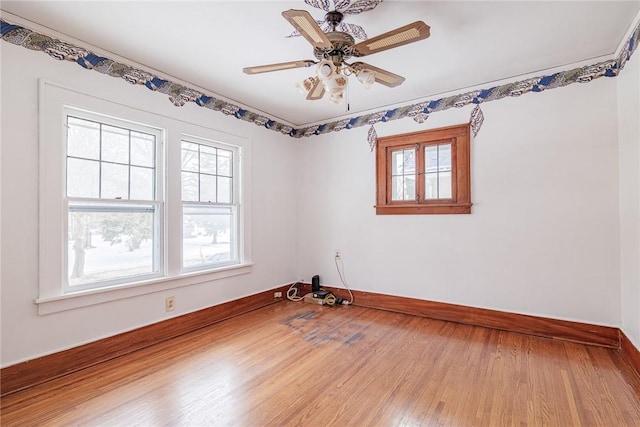 unfurnished room featuring ceiling fan, baseboards, plenty of natural light, and wood finished floors