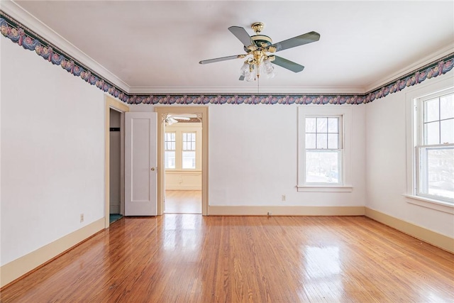 unfurnished room featuring plenty of natural light, baseboards, light wood-type flooring, and ornamental molding