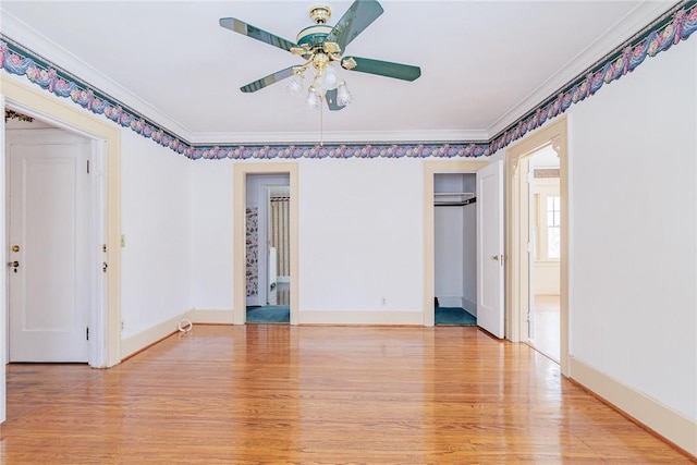 spare room featuring baseboards, crown molding, and light wood-style floors