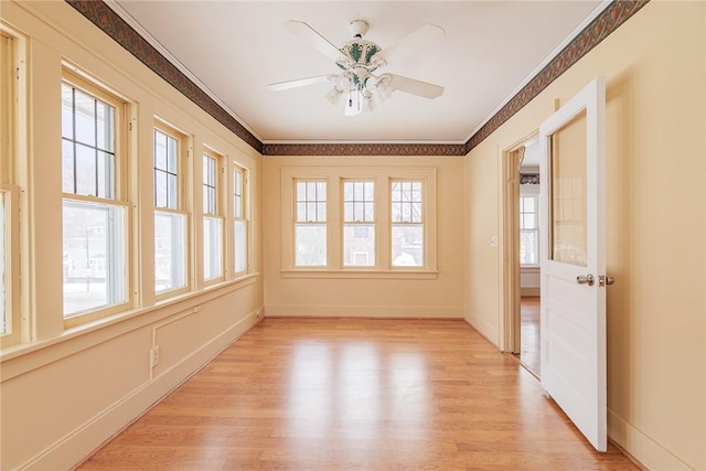 unfurnished sunroom featuring plenty of natural light and a ceiling fan