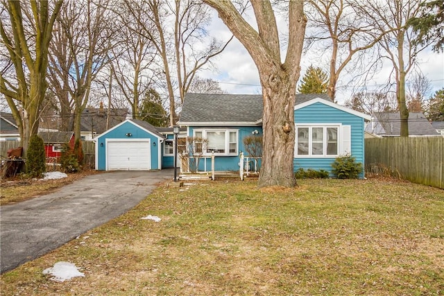 ranch-style home featuring fence, a front yard, a garage, an outdoor structure, and driveway