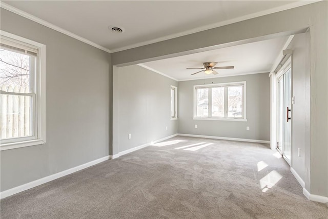 carpeted empty room with crown molding, visible vents, baseboards, and ceiling fan