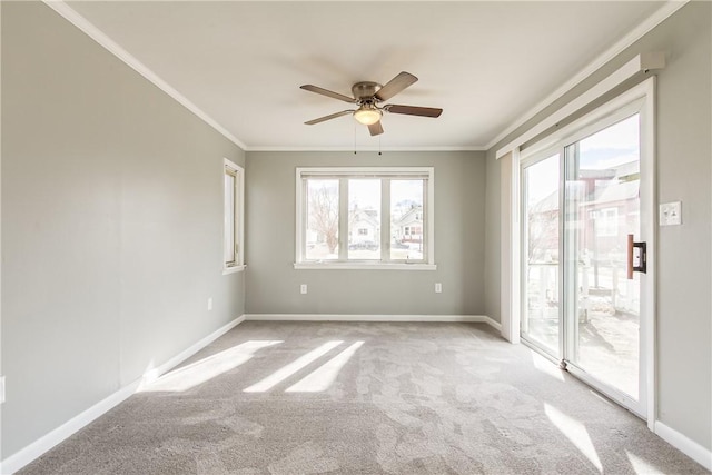 empty room featuring baseboards, light carpet, a ceiling fan, and crown molding