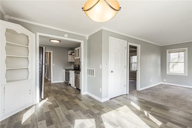 unfurnished living room featuring visible vents, dark wood-style floors, baseboards, and ornamental molding