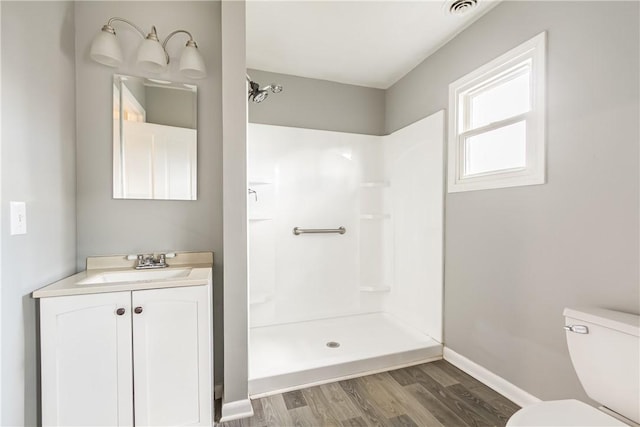 full bathroom featuring vanity, wood finished floors, visible vents, a shower, and toilet