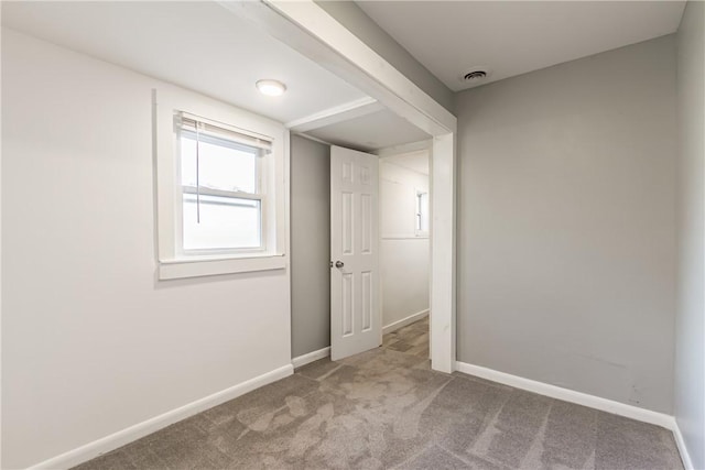 unfurnished room with visible vents, baseboards, and carpet flooring