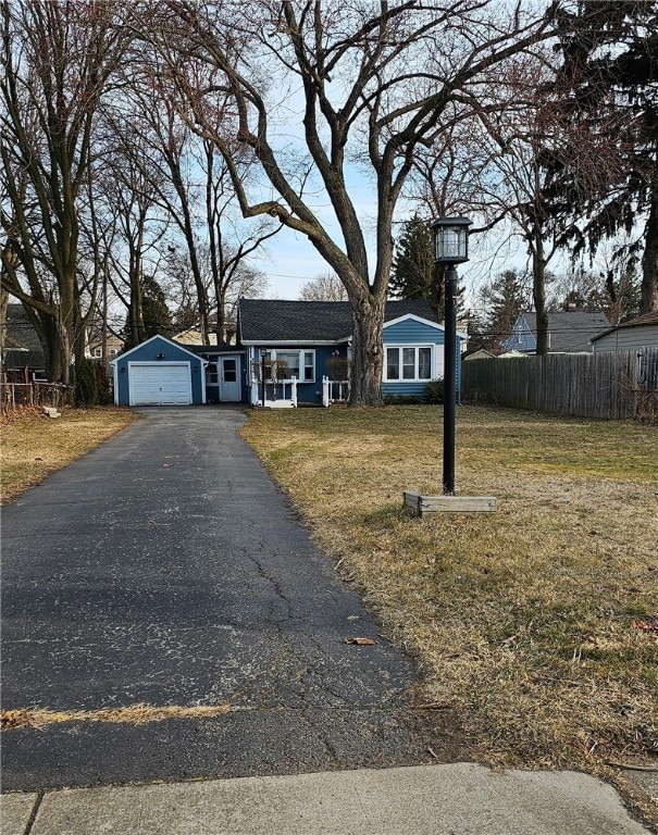 view of front of home with a front lawn, fence, and driveway