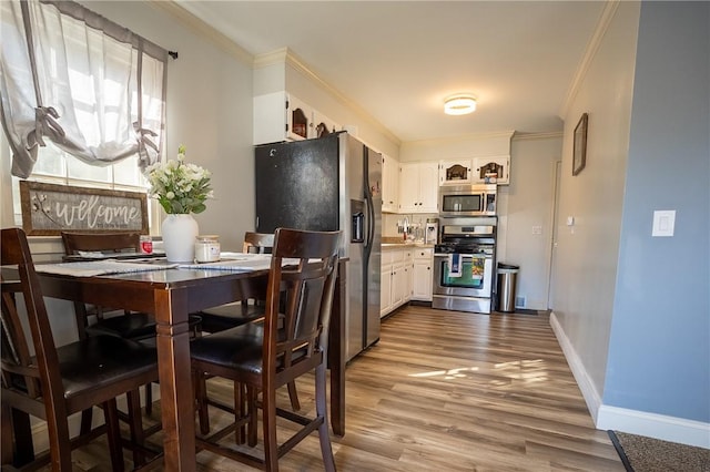 kitchen with baseboards, ornamental molding, white cabinets, stainless steel appliances, and dark wood-style flooring