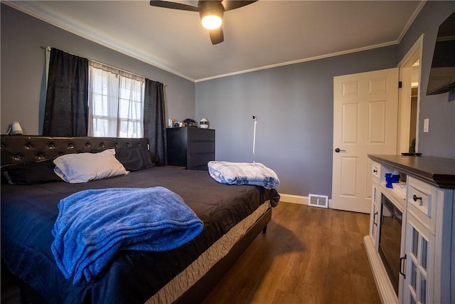 bedroom featuring ceiling fan, visible vents, dark wood-style floors, and crown molding