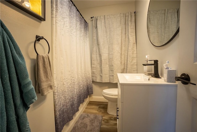 bathroom featuring toilet, vanity, a shower with curtain, and wood finished floors