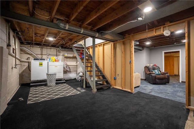 unfinished below grade area featuring stairs and washing machine and dryer