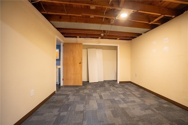 finished basement featuring wooden ceiling, carpet, and baseboards