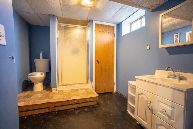 full bathroom featuring vanity, a shower stall, toilet, and a paneled ceiling