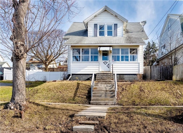 bungalow with fence and a shingled roof