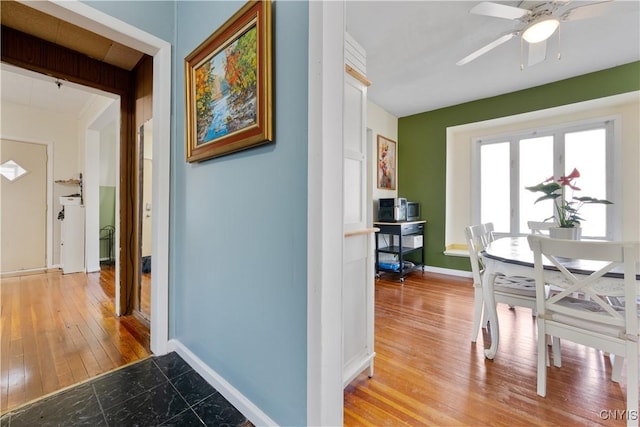 hallway featuring light wood-type flooring and baseboards