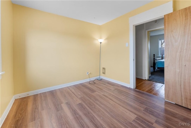 unfurnished room featuring baseboards and wood finished floors