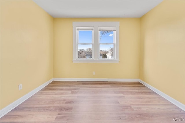 empty room featuring light wood-style flooring and baseboards