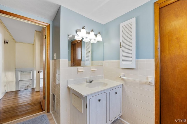 bathroom featuring tile walls, wainscoting, and vanity