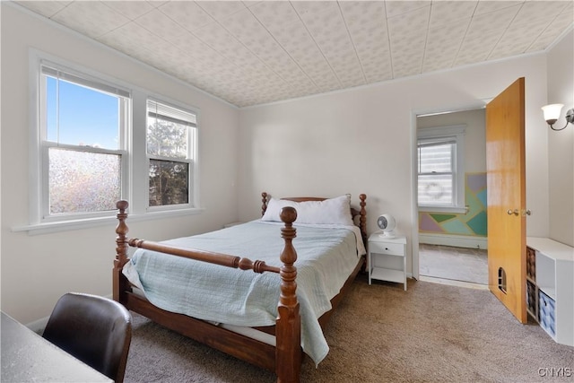 bedroom featuring multiple windows, ornamental molding, and carpet flooring