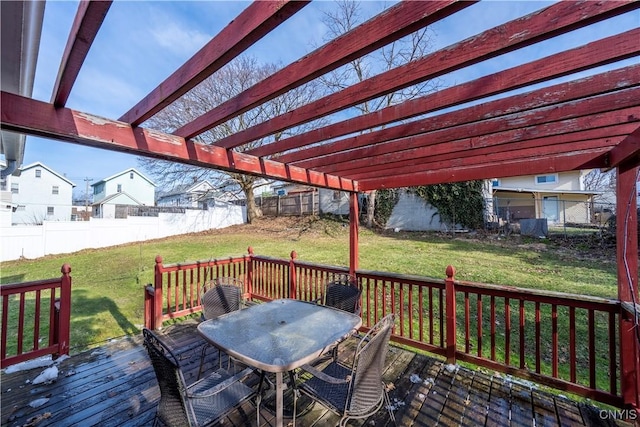 deck with outdoor dining area, a lawn, a pergola, and a fenced backyard