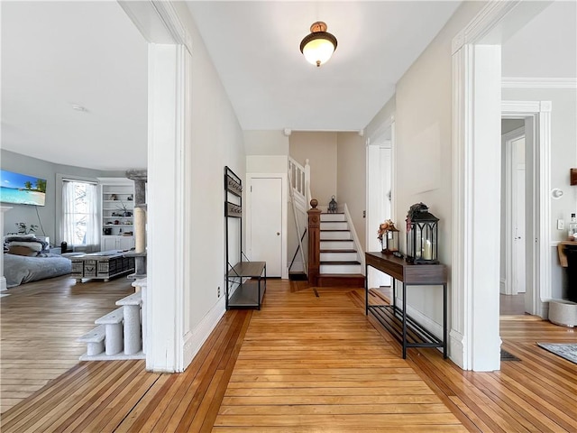 entrance foyer with stairs, light wood-style floors, and baseboards