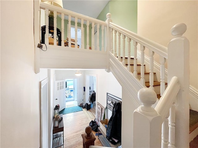 stairs with a high ceiling and wood finished floors